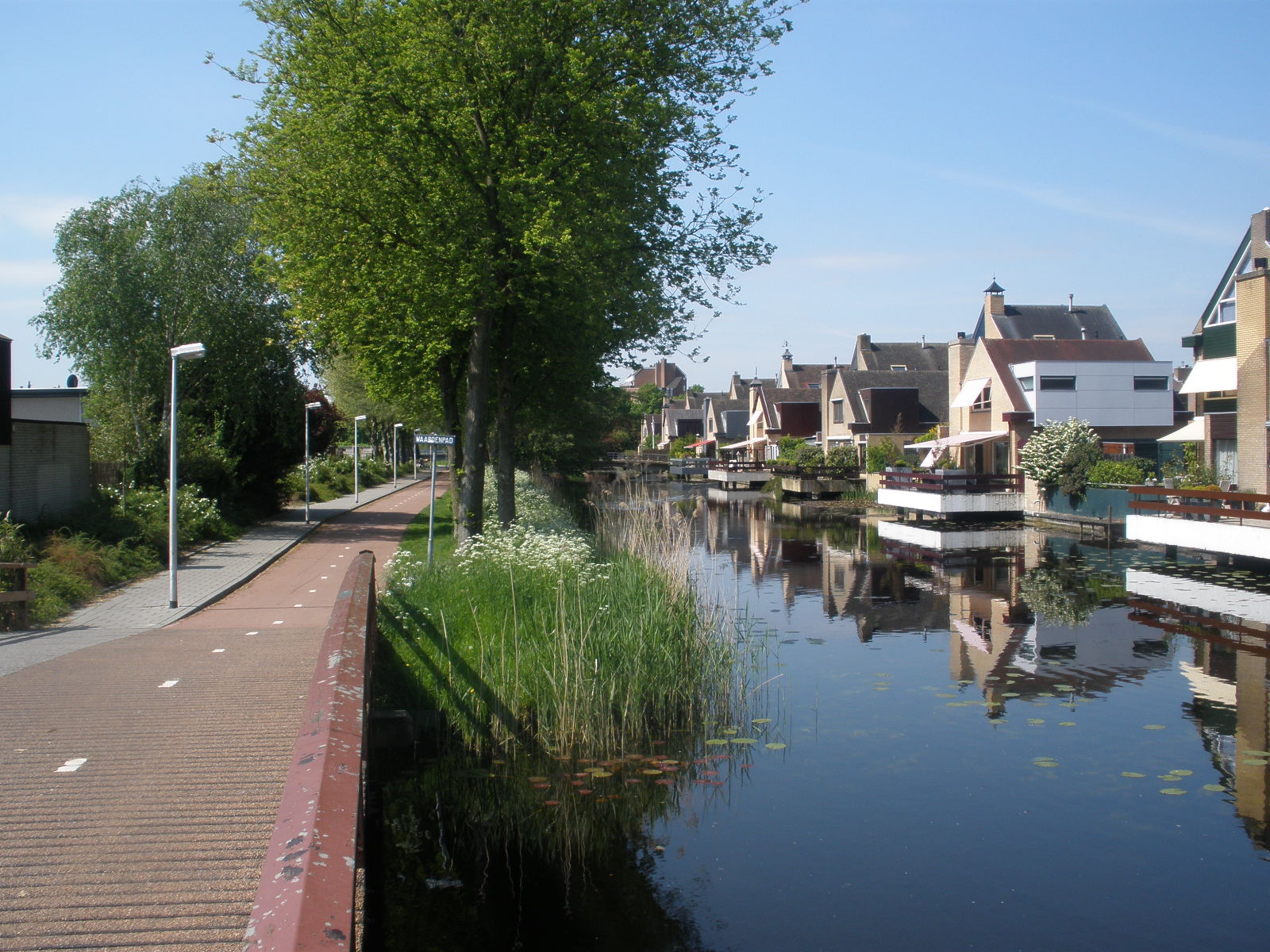 Natuurlijke berm aan de ene oever en tuinen aan de andere oever